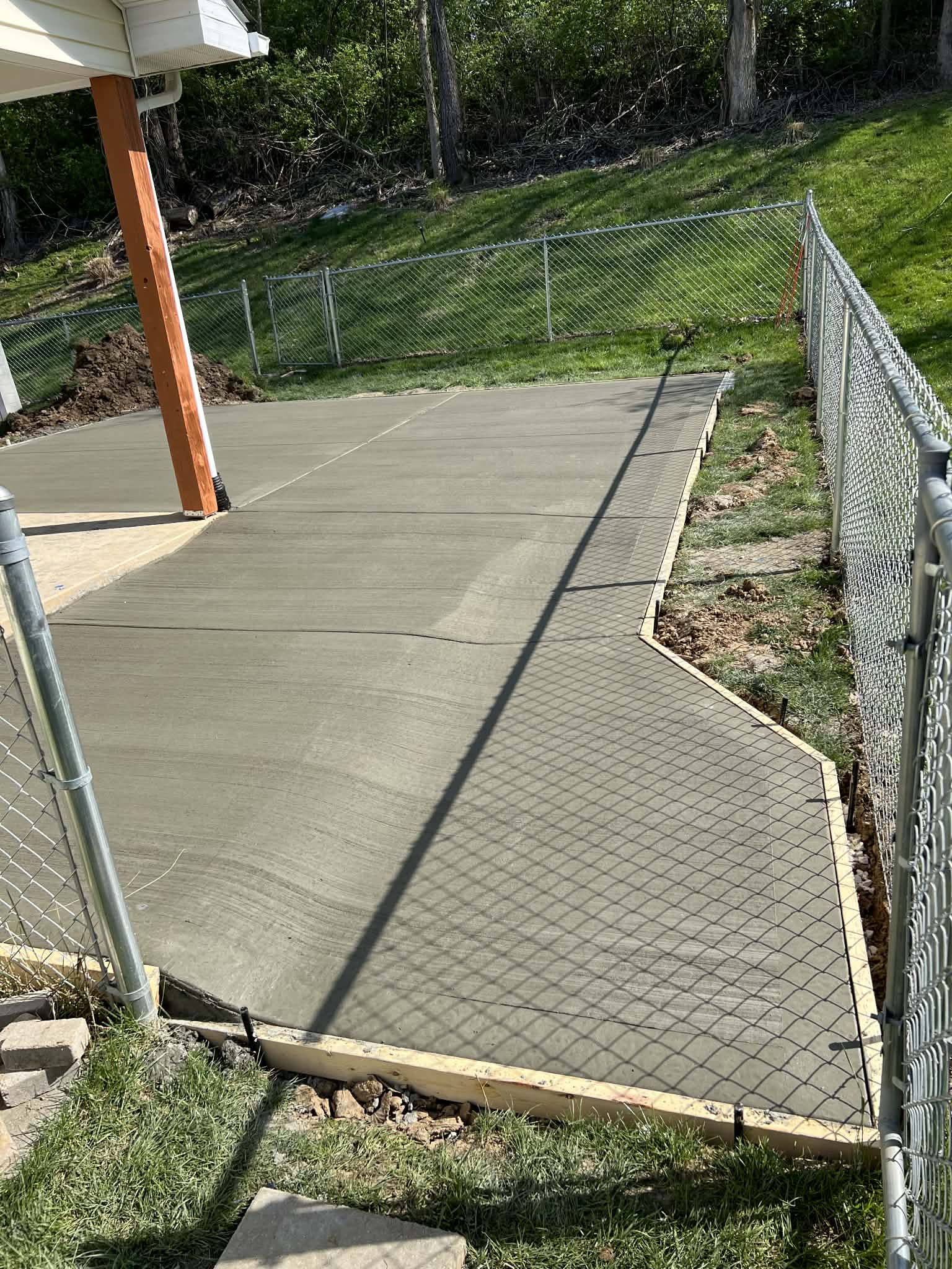CW Concrete - fresh concrete walkway along fenced backyard